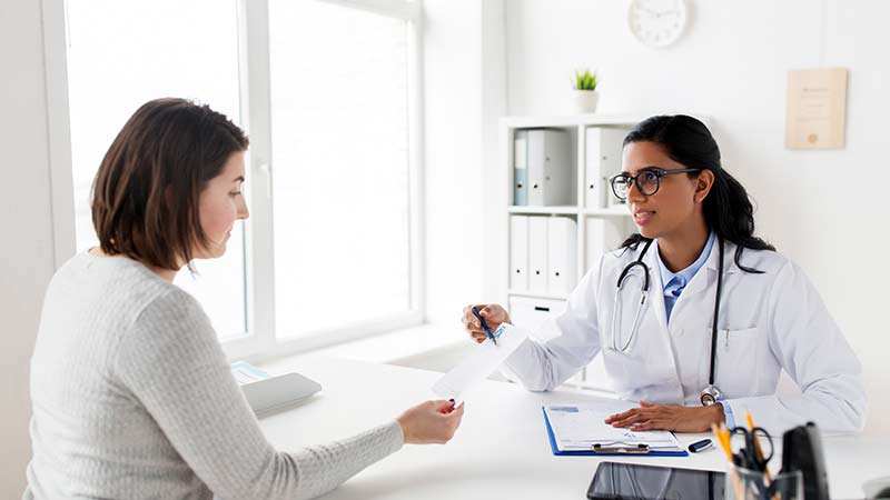 a female doctor goes over a piece of paper with a female 