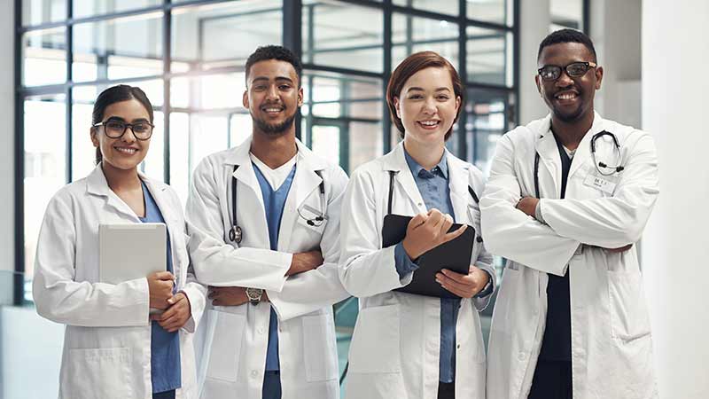 Diverse physicians standing in line smiling