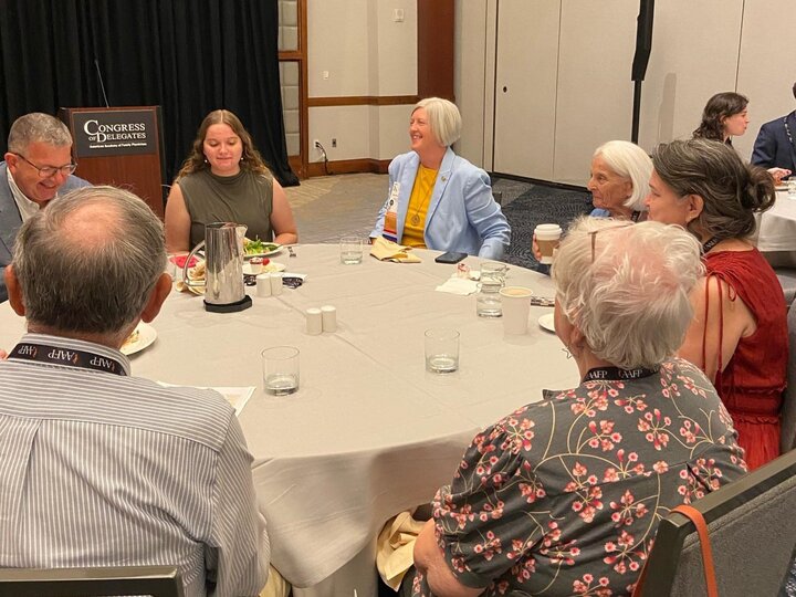 Seven people sitting around a table having a discussion from the Congress of Delegates