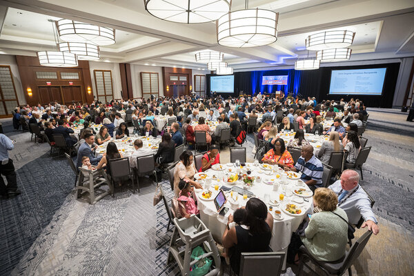 large convention room with round tables of people for the convocation breakfast