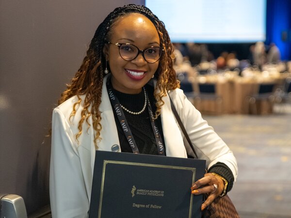 Woman physician holding award