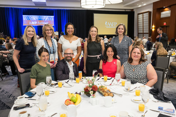 Multiple people smiling up close attending convocation breakfast