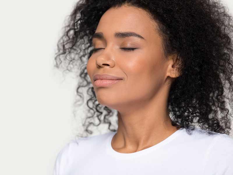 Close up of young black woman with eyes closed breathing deeply