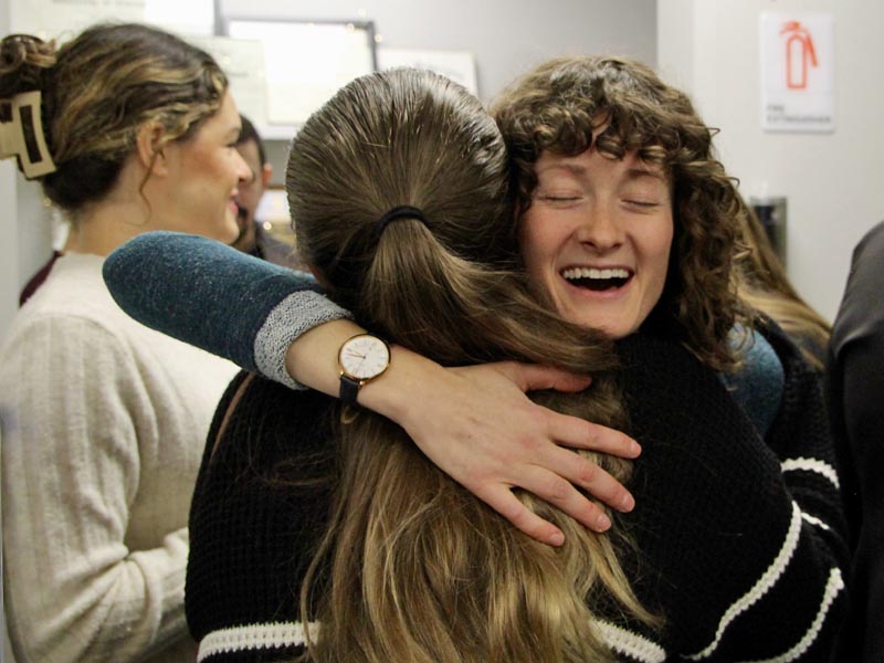 two ladies hugging each other. 