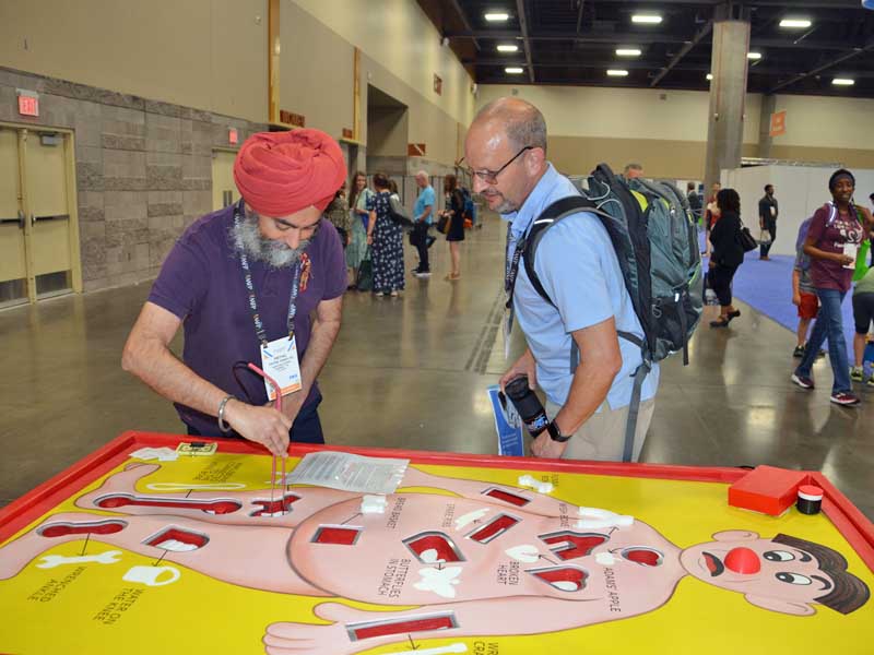 Pritpal Singh, D.O., tries his hand at a game of Giant Operation with colleague Samuel Balk, M.D.